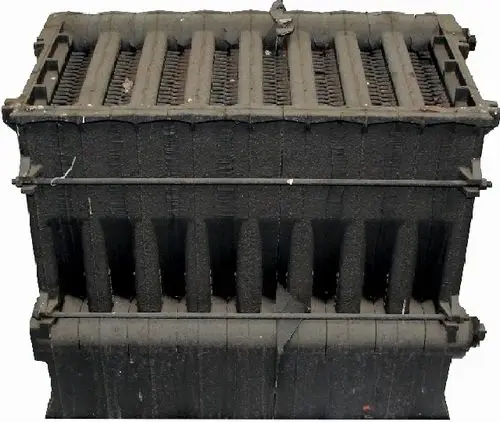 Schwarzer Gussblock mit rippigen Oberflächenstrukturen, Teil eines Heizsystems von Wolf, standardisierte Bauform zur effizienten Wärmeübertragung.